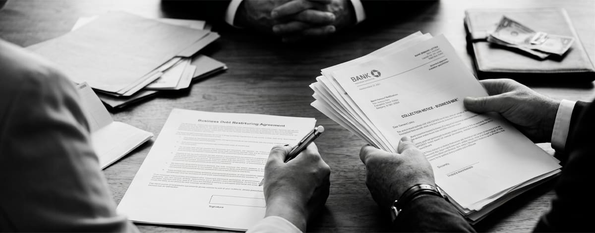 Advogado em reunião com empresário analisando a dívida bancária da empresa