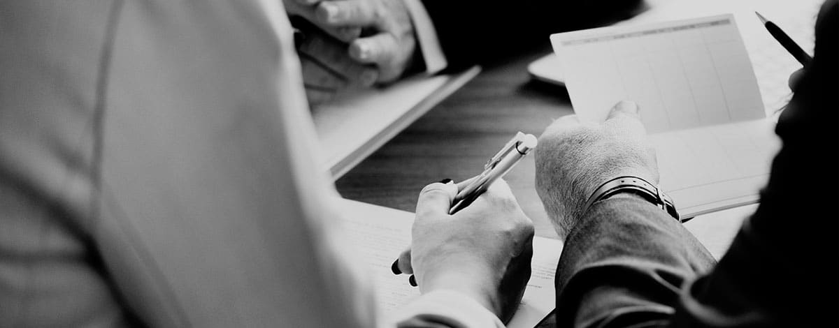 Cliente e advogado revisando e assinando documentos de um refinanciamento bancário